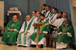 Priests and Altar Servers listening to the homily.