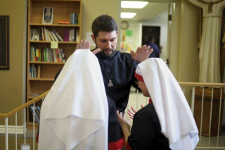 Fr. Isaac Longworth, CC praying over Servants of the Cross.
